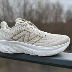 Jasny beżowy but sportowy New Balance z grubą białą podeszwą. Zastanawiasz się, co to jest drop? To różnica wysokości między piętą a palcami buta, która wpływa na komfort biegu.