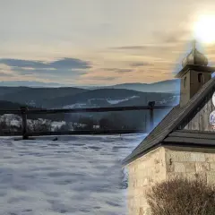Zimowy krajobraz na Koskowej Górze z kapliczką i widokiem na góry.