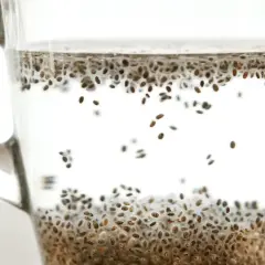 Szklanka z wodą i nasionami chia, które zaczynają pęcznieć, tworząc żelową konsystencję. Zdrowy napój.