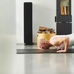 Mężczyzna wykonuje pompkę na macie. To jego trening kalistenika w domu.