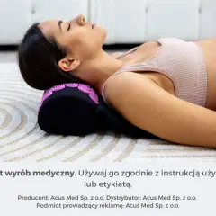 Kobieta leży na macie, z głową opartą na wałku z kolcami. To jeden z domowych sposobów na ból szyi i karku.