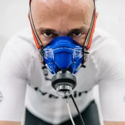Mężczyzna w masce do testów wydolnościowych, przygotowuje się do badania VO2max.