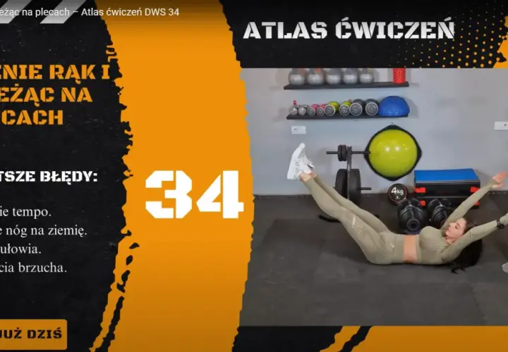 Kobieta wykonuje ćwiczenie unoszenia rąk i nóg leżąc na plecach. W tle siłownia z akcesoriami do treningu.