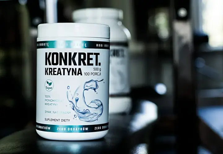 Biały słoik z napisem "KONKRET. KREATYNA" i grafiką wody. To suplement diety, jaka kreatyna dla Ciebie?