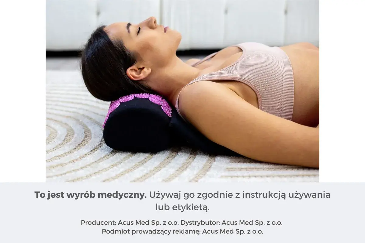 Kobieta leży na macie, z głową opartą na wałku z kolcami. To jeden z domowych sposobów na ból szyi i karku.