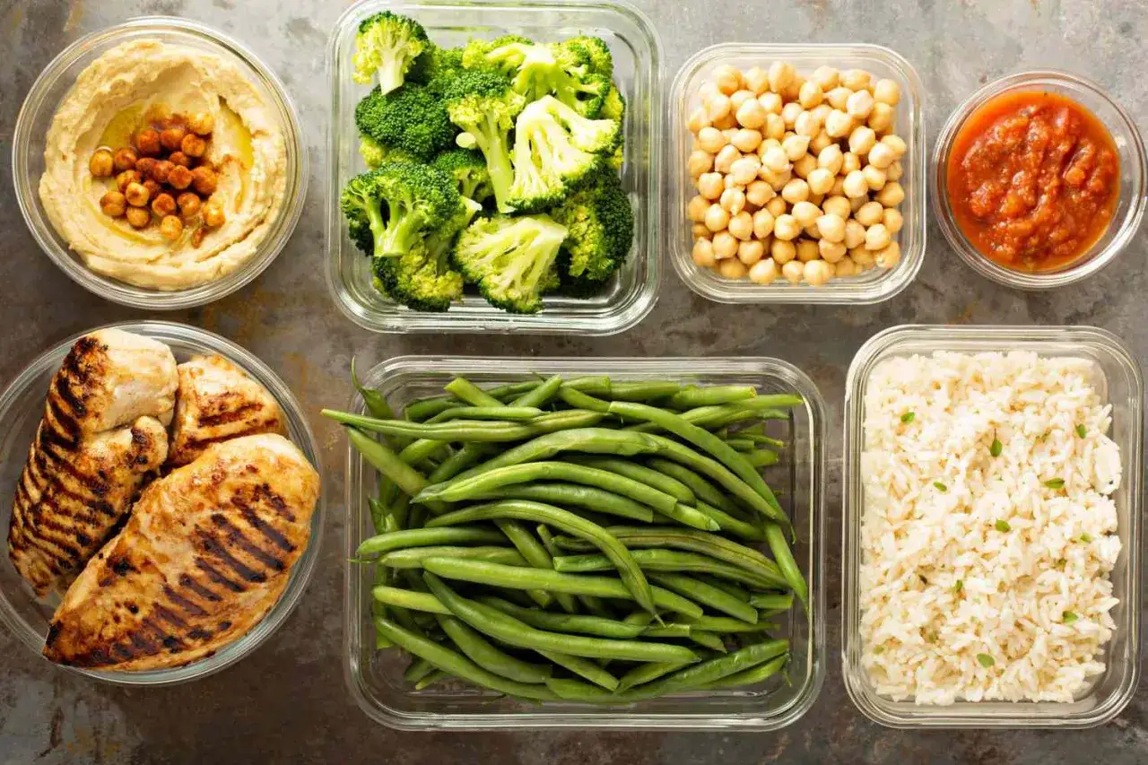 Zdrowe posiłki do meal prepu: grillowany kurczak, brokuły, fasolka szparagowa, ryż, ciecierzyca, hummus i sos pomidorowy. Klucz do tego, jak schudnąć z brzucha.