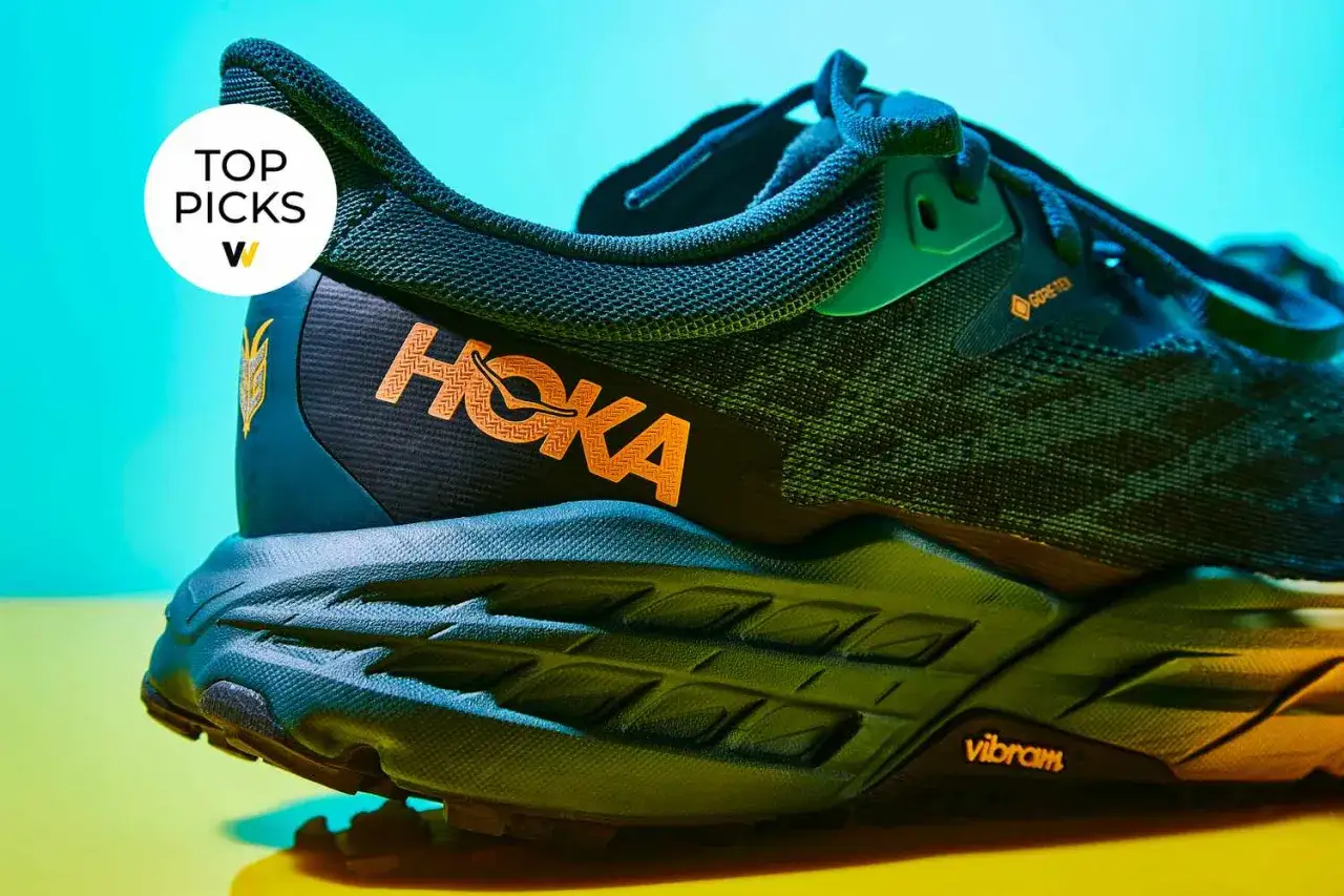 Buty Hoka z pomarańczowym logo. Hoka to firma znana z innowacyjnych butów do biegania i trekkingu, oferująca komfort i wsparcie.