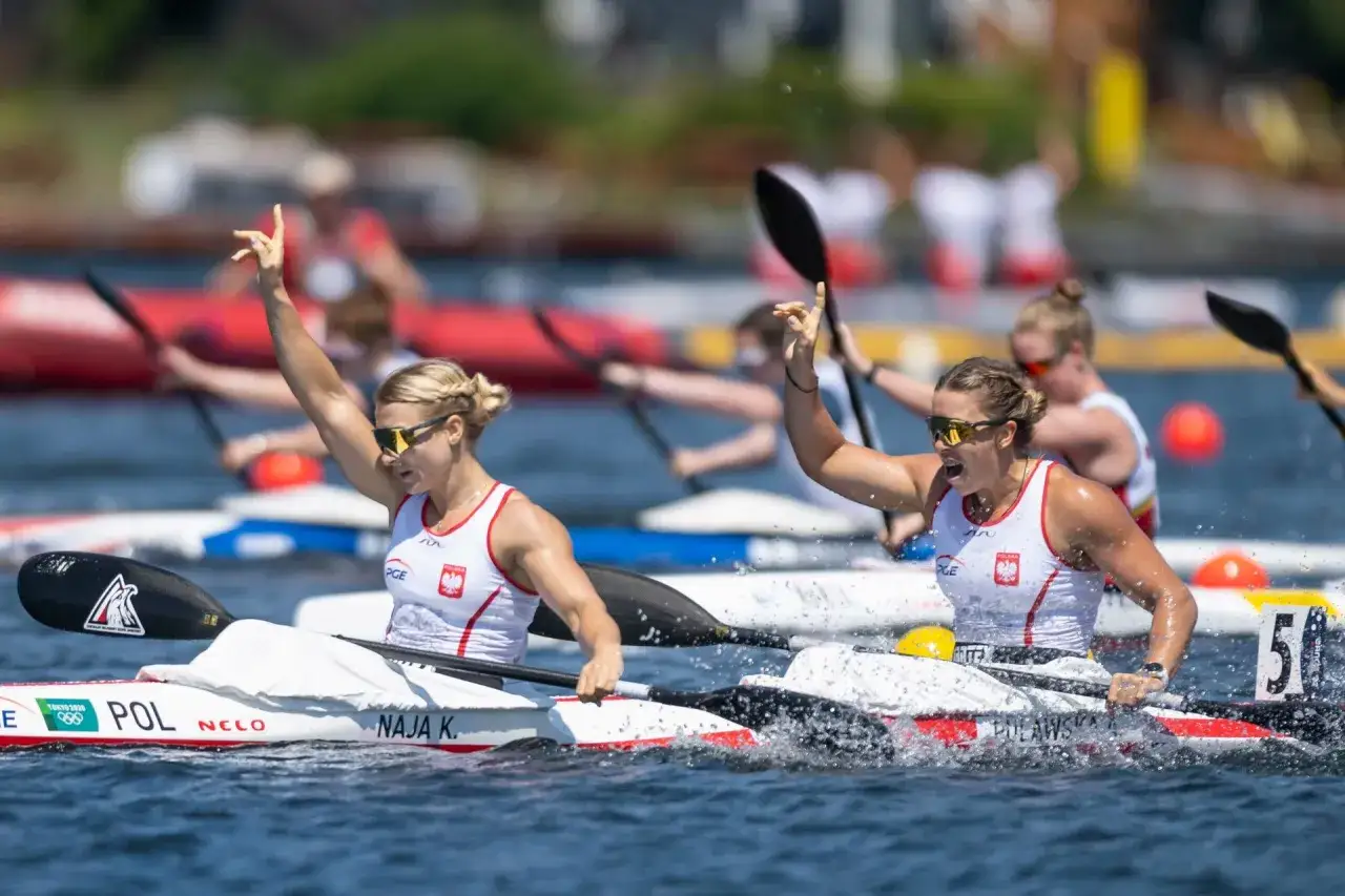 Dwie sportsmenki w biało-czerwonych strojach świętują sukces w kajakarstwie na IO.